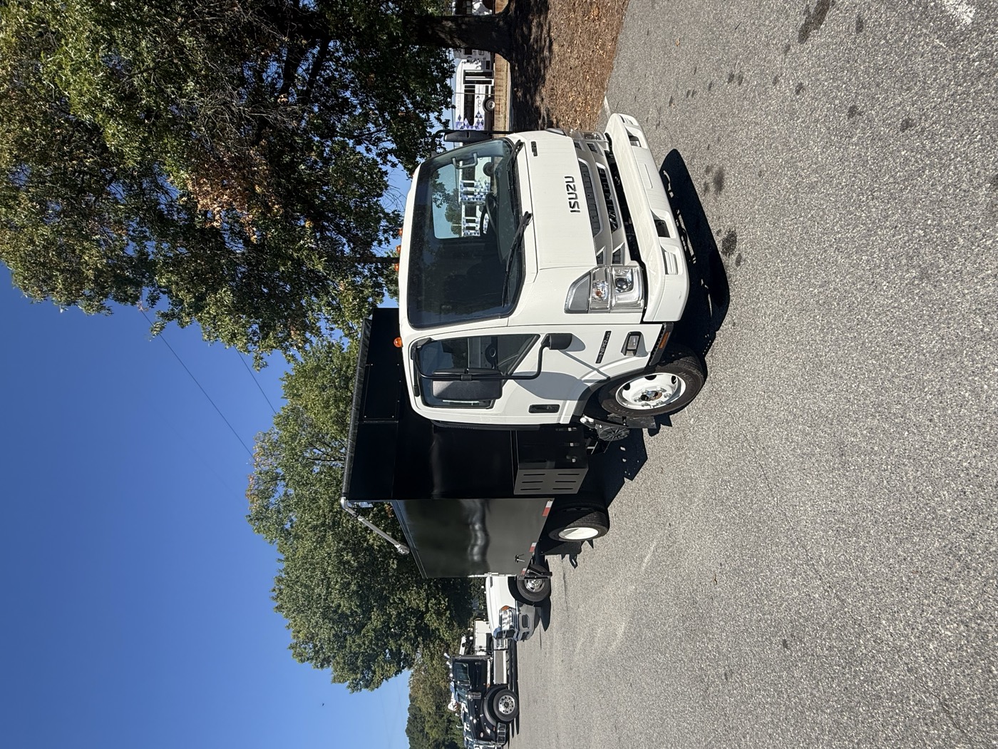 2026 Isuzu NPR HD with a black STB junk removal body, front passenger side